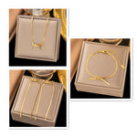Ruban — bracelet à droite dans la gamme dorée ; collier et boucles non inclus.