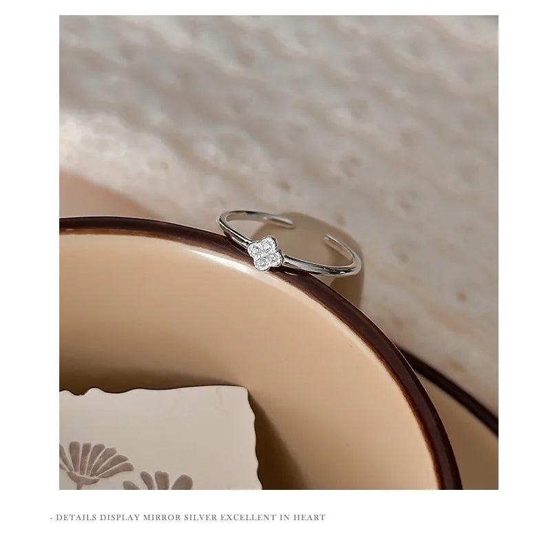 Charme — bague ouverte à motif serti, présentée sur un support.