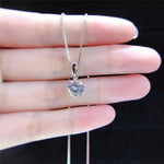 Halo — pendentif rond et chaîne, présentés dans la main.